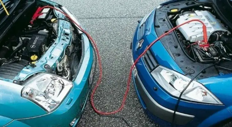 2 voitures face à face avec des câbles de démarrage branchés aux batteries